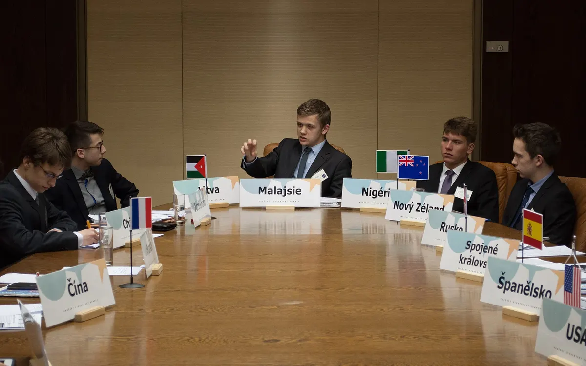 A model Security Council in session, delegates seated around a large table behind small flags and nameplates