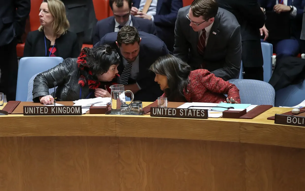 The British and United States ambassadors confer with their teams at their seats in the UN Security Council after a vote
